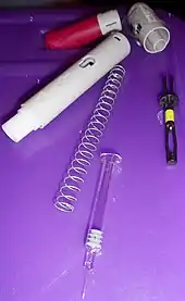 Components of a Humira autoinjector pen.