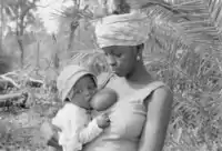 Standing mother breastfeeding her baby, Canjambari, Guinea-Bissau, 1973